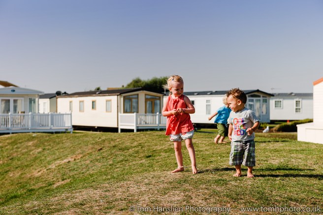 Kids playing on the lawn by the caravans.